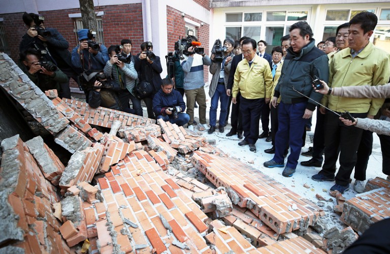 Crowd inspects damaged buildings after earthquake