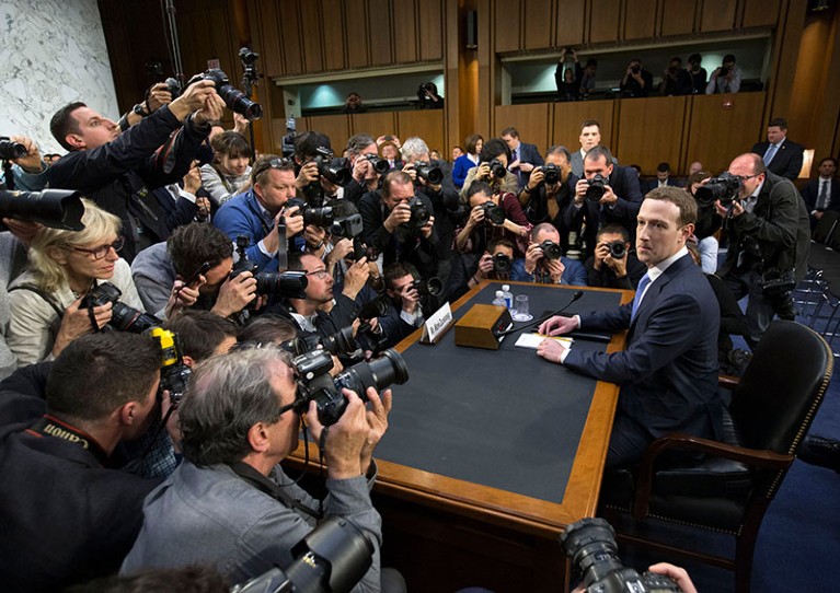 CEO of Facebook Mark Zuckerberg (R) takes his seat to testify before a Senate joint hearing on 10th April 2018.