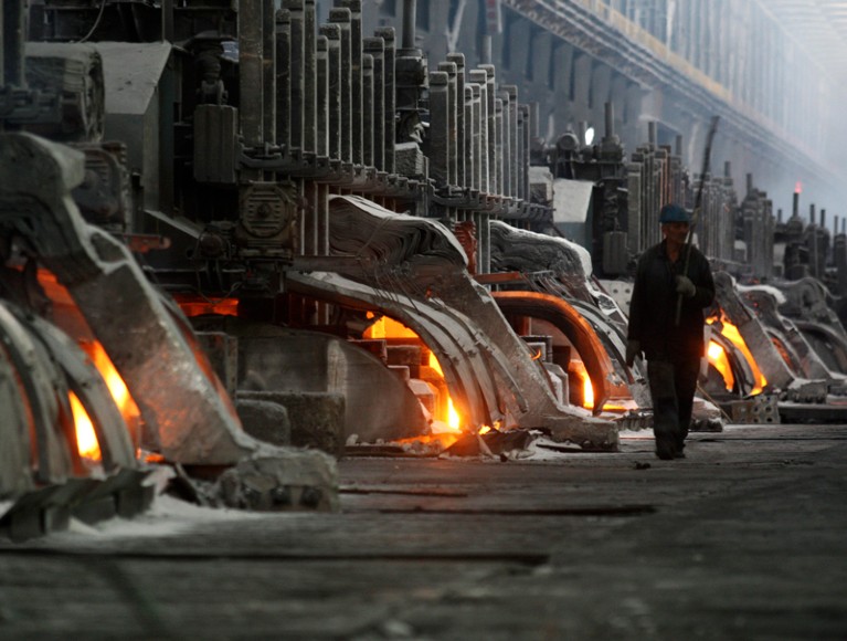 A worker walks through an aluminium smelting complex