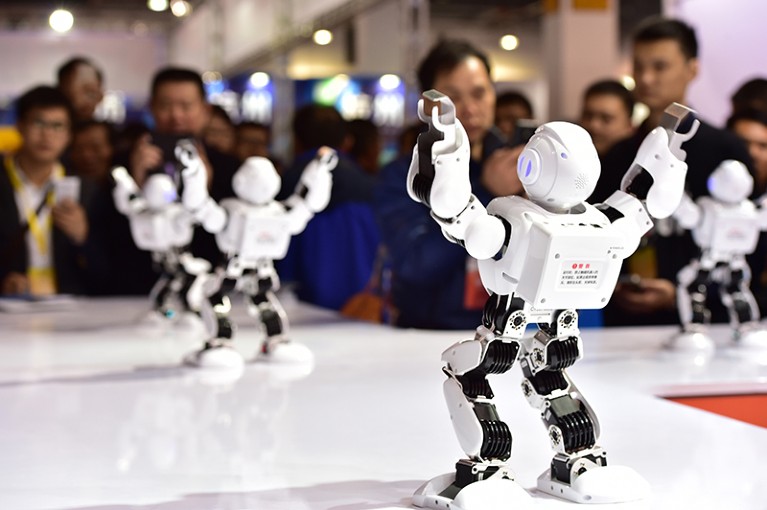 Visitors watch a robot during the 2015 China Yiwu International Manufacturing Equipment Expo & China Intelligent Expo