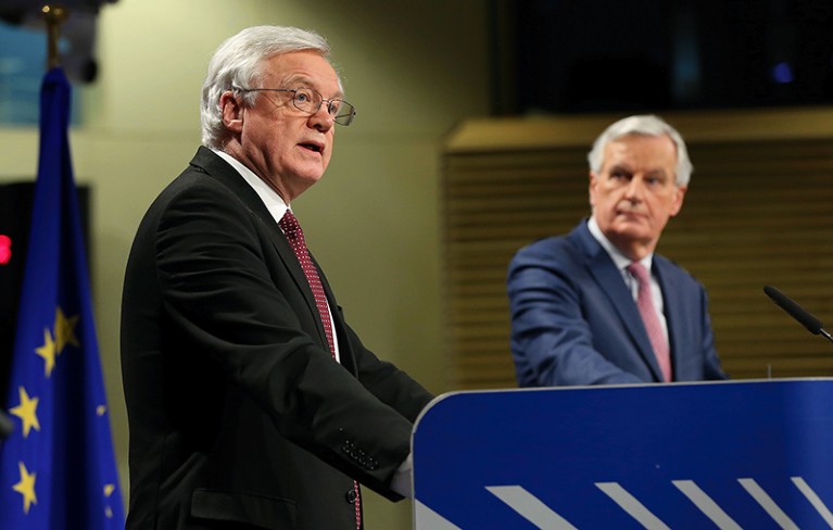 David Davis speaks as Michel Barnier watches during a press conference following Brexit talks in Brussels on March 19th 2018.