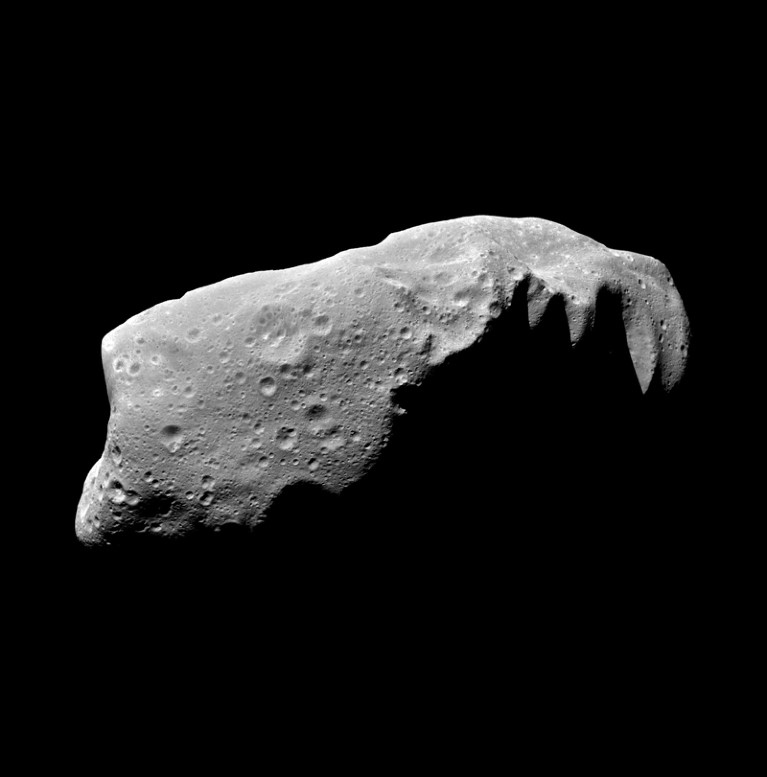 A grey, cratered asteroid against a black background.