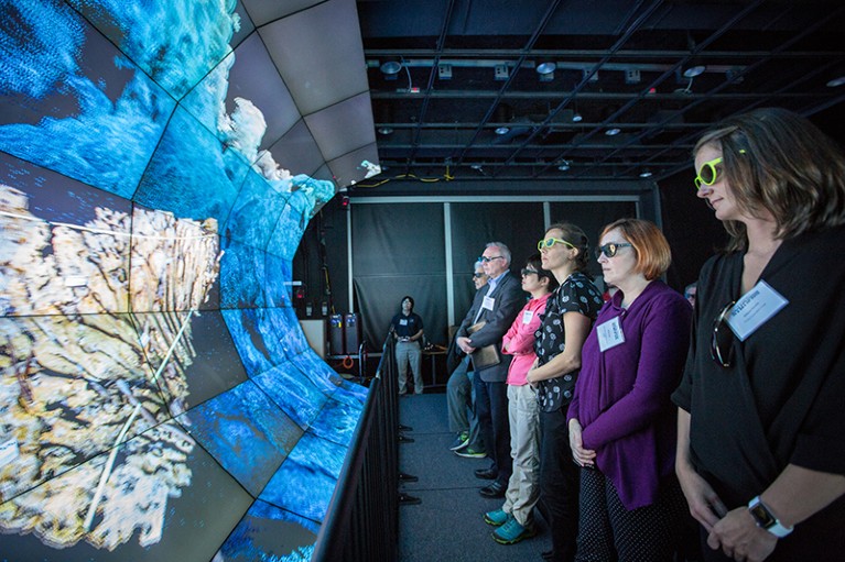 Users look at the 3D visualization system known as WAVE, used to explore ocean worlds
