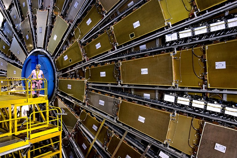 A scientist standing in front of the ATLAS detector.