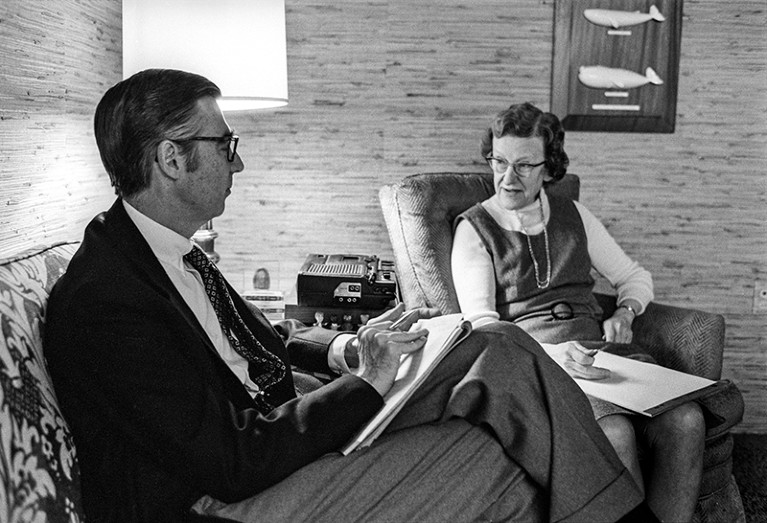 Fred Rogers (l) talks to Margaret McFarland (r) in this black and white photo. They are both seated and holding large notepads