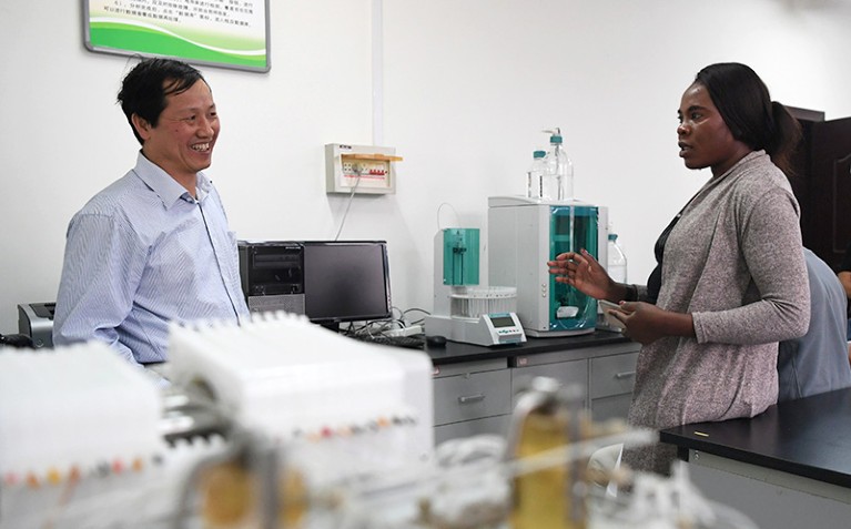 A Namibian agricultural technology officer (R) learns about combating desertification from a scientist (L) in a lab in Lanzhou.