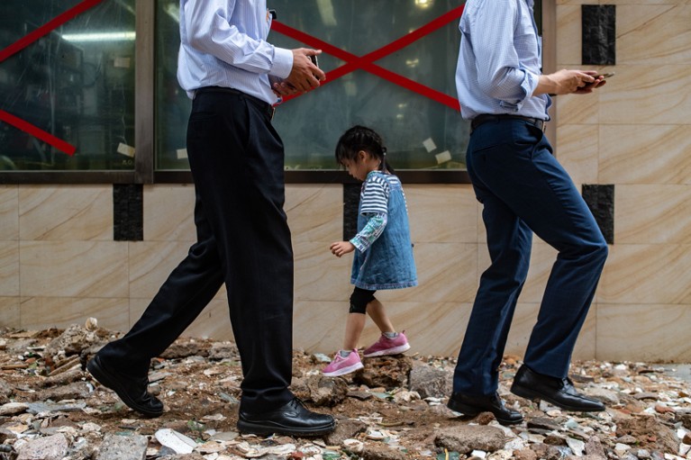 People walk on a path covered in debris caused by Typhoon Mangkhut