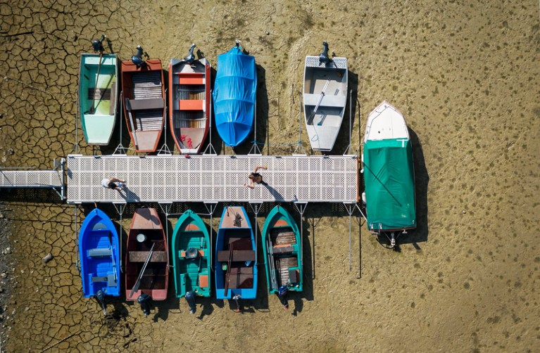 Boats beside a jetty on the dried out lake bed