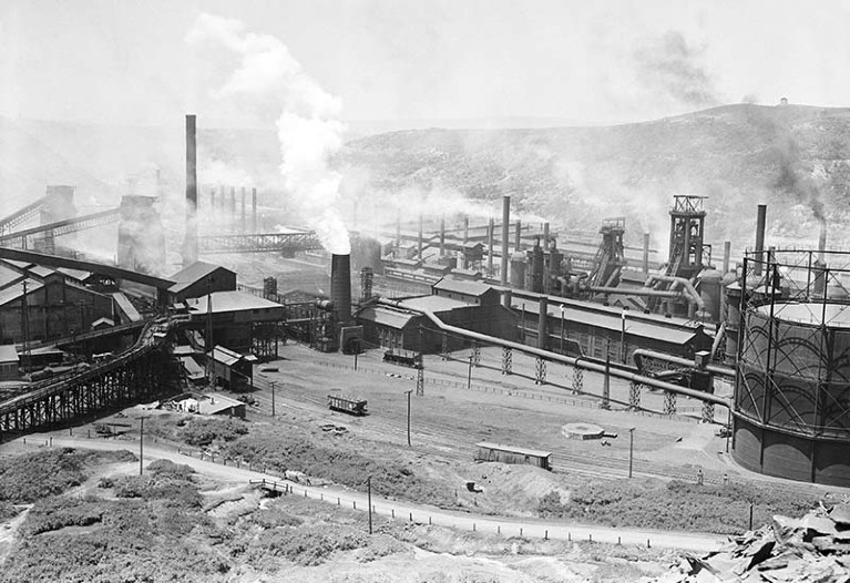 Black and white photo of Bethlehem Steel Mill in Johnstown, PA, from a hill. Smoke rises from the stacks