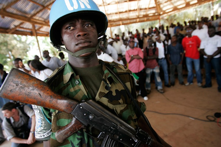 A United Nations peacekeeper stands guard at an election rally in Liberia