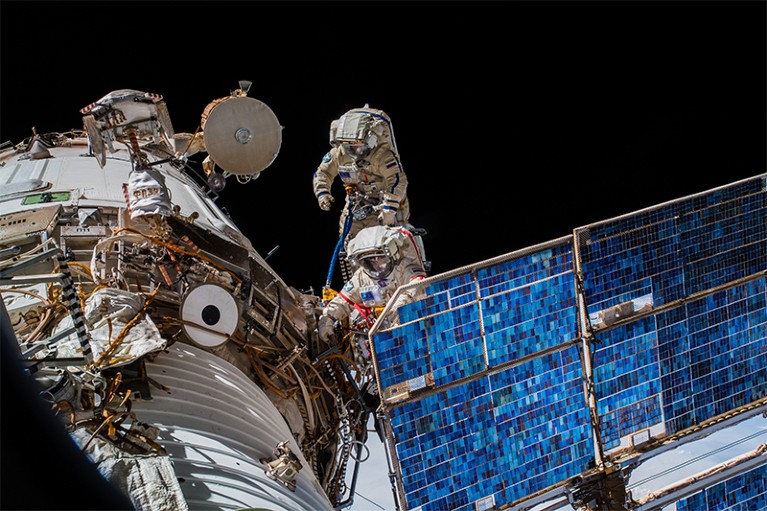 两名宇航员(c)将ICARUS卫星连接到国际空间站的天线上