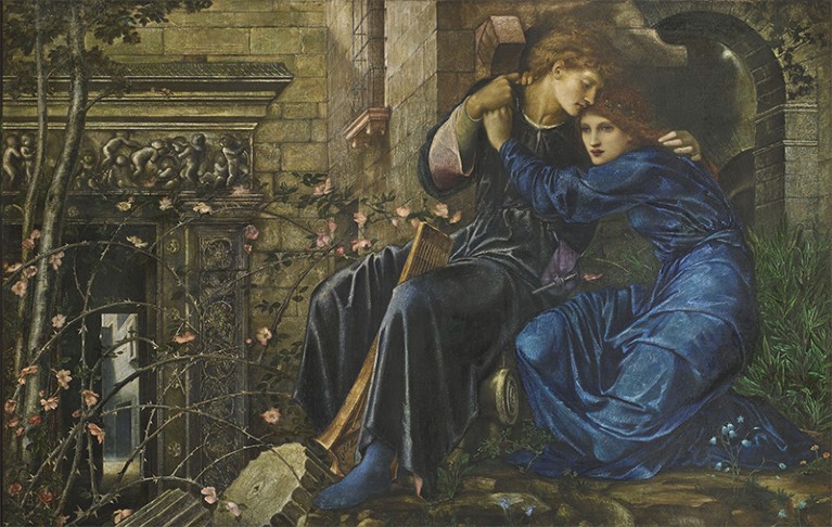 A painting of two lovers, one with an instrument, sit entwined amongst ruins and rose brambles. By Edward Burne-Jones