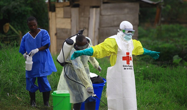 A health worker sprays disinfectant on his colleague after working at an Ebola treatment center in Beni, Eastern Congo