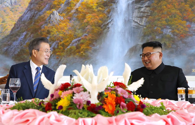 President Moon Jae-In (l) + Leader Kim Jong-Un (r) smile at each other over an elaborate table setting during Moon's Sept visit