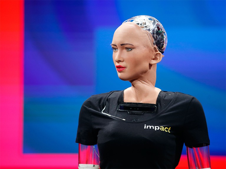 Humanoid robot 'Sophia' appears to frown at the audience at a digital forum.