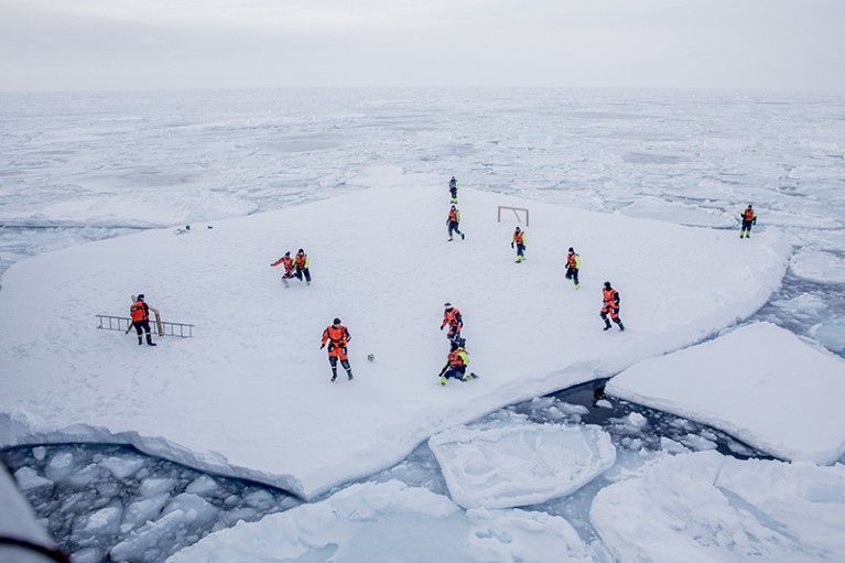 Scientists play football on the ice.