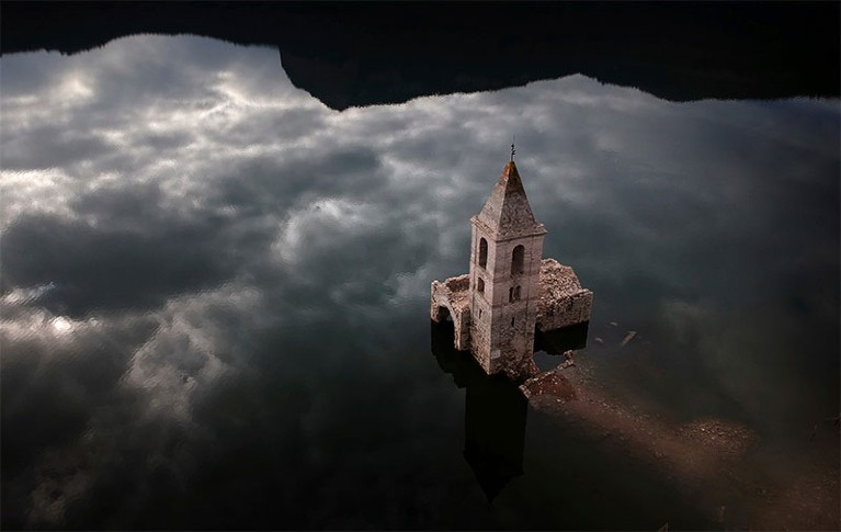 An 11th century village and church, which are usually covered by water, are partially exposed in a reservoir in Spain