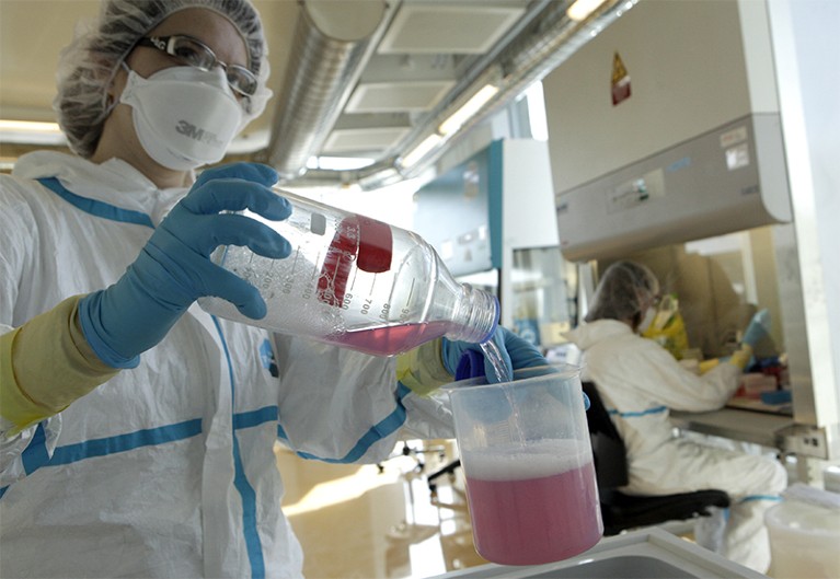 Lab assistant pours liquid in a P3 level tuberculosis laboratory in 2010
