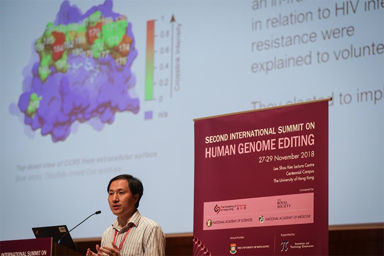 He Jiankui talks at the Human Genome Editing summit in Hong Kong. Behind him is a slide showing a CRISPR CAS molecule