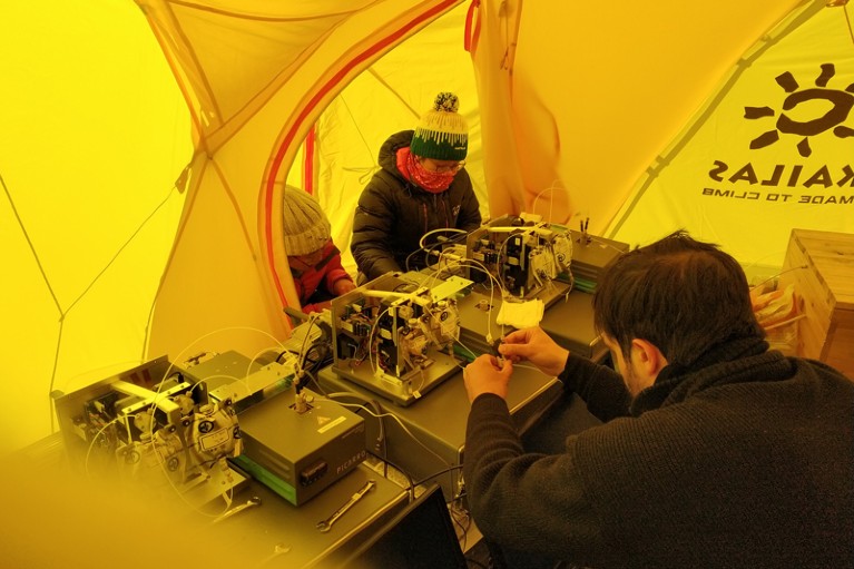 Researchers set up instruments in a tent