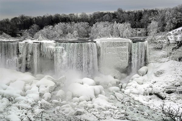 Water flows around ice, formed on the American Falls in Niagara Falls, New York, due to subzero temperatures