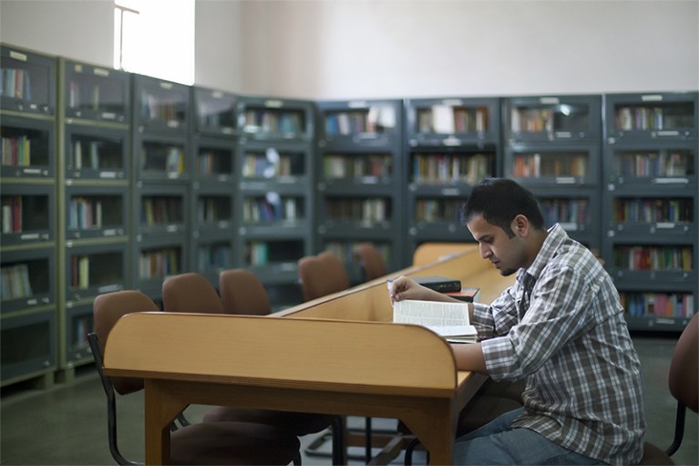 Young man reading in a library in India