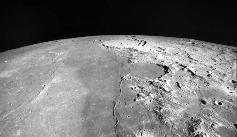 View of the Moon's horizon, with a flat plain on the left and a rocky landscape on the right.