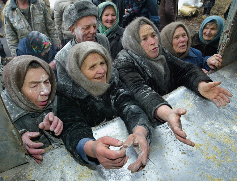 Elderly women gather around a truck to receive food supplies from Ukraine's Emergencies Ministry in Illintsi.