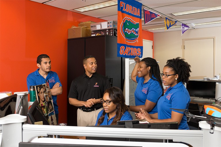 Professor Juan Gilbert (second from left) interacts with his team in their workroom the University of Florida