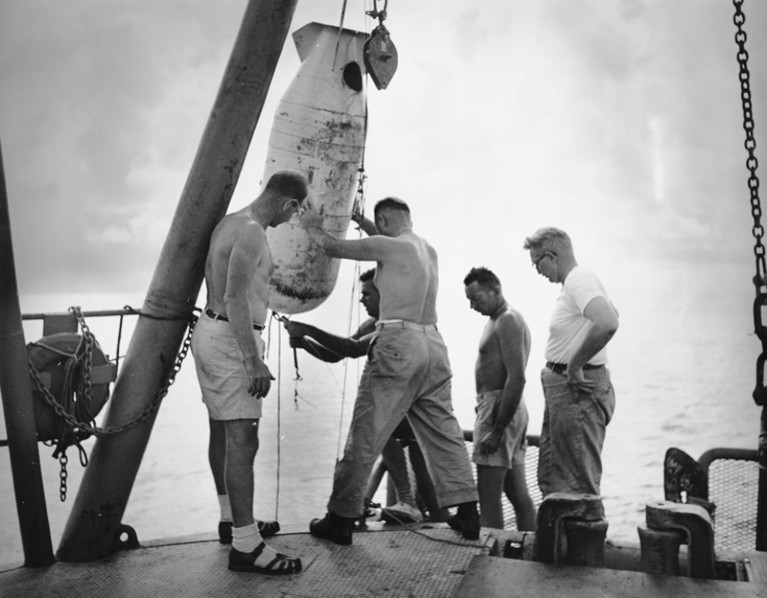 Walter Monk and colleagues inspect an oceanographic instrument during an expedition in the Pacific Ocean 1952-1953.