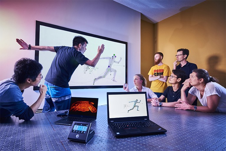 A team of reserachers watch motion-capture technology on a screen