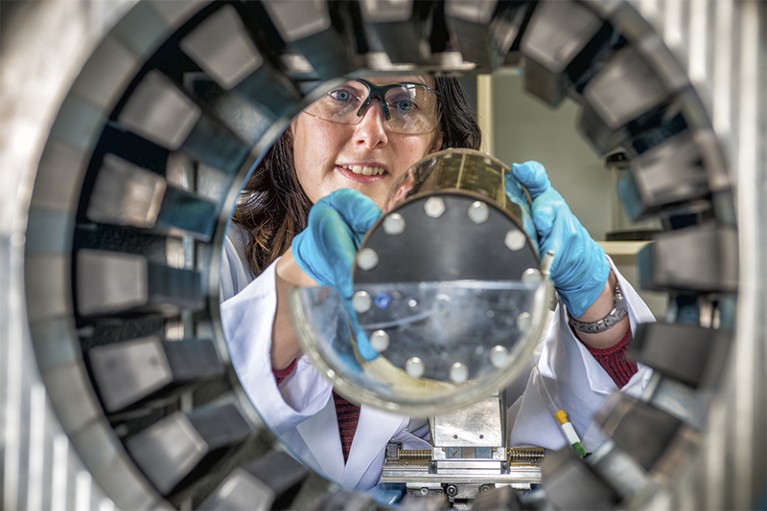 Researcher places cylinder inside PET camera.