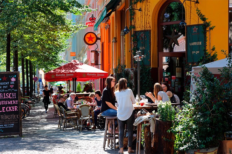 People sitting at tables outside a cafe.