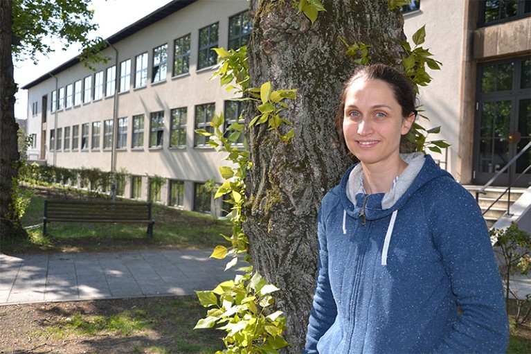 伊娃·昂格尔在学院大楼旁的一棵树前。