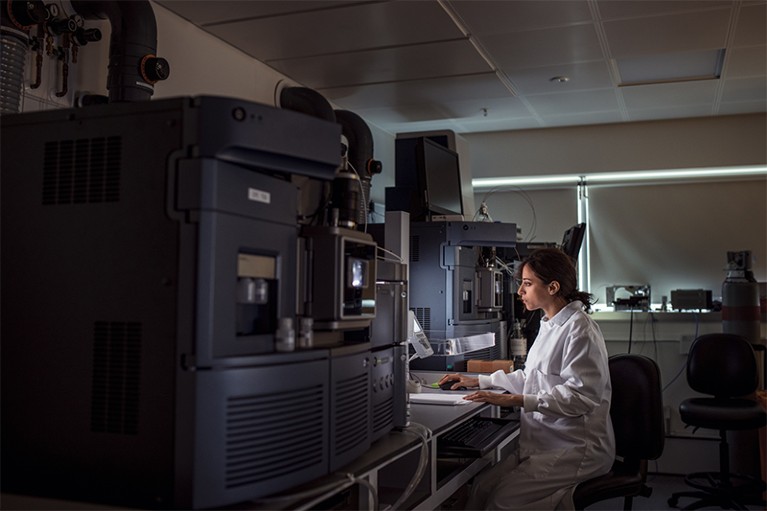 在灯光昏暗的实验室里，一位女性生物化学家忧心忡忡地看着电脑屏幕