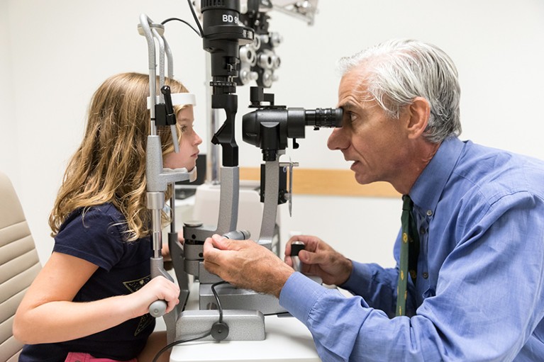 眼科医生艾伯特·马奎尔检查眼睛的女孩