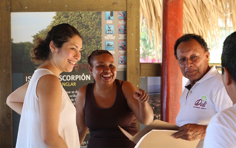 Maria Avila smiles with participants while returning ancestry results as part of an Afromexico genomics project