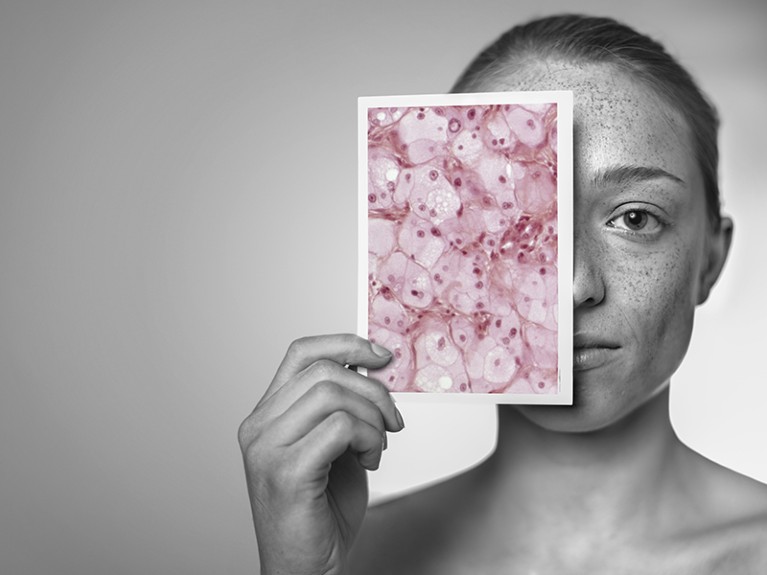 Woman holding a light micrograph in front of her face showing facial skin damage