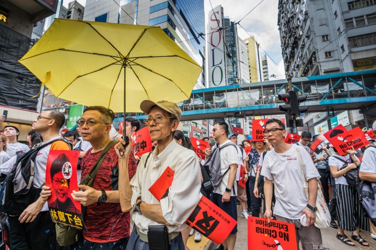 Demonstrators with a yellow umbrella marching in Hong Kong against an extradition bill proposed by the government
