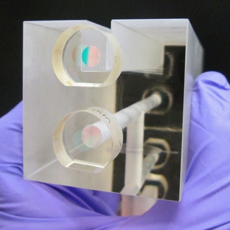 A NIST researcher holds a fixed length optical cavity (FLOC)