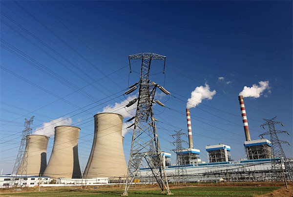 Smoke and steam are discharged from chimneys and cooling towers in Huaian city, China.
