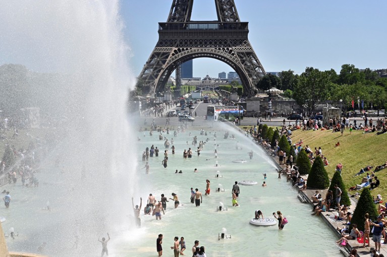 People cool down in the fountains of Trocadero near the Eiffel Tower during a heatwave in Paris, France
