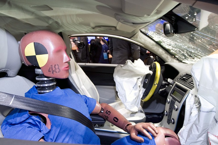 A crash test dummy on display in a vehicle that was test-crashed
