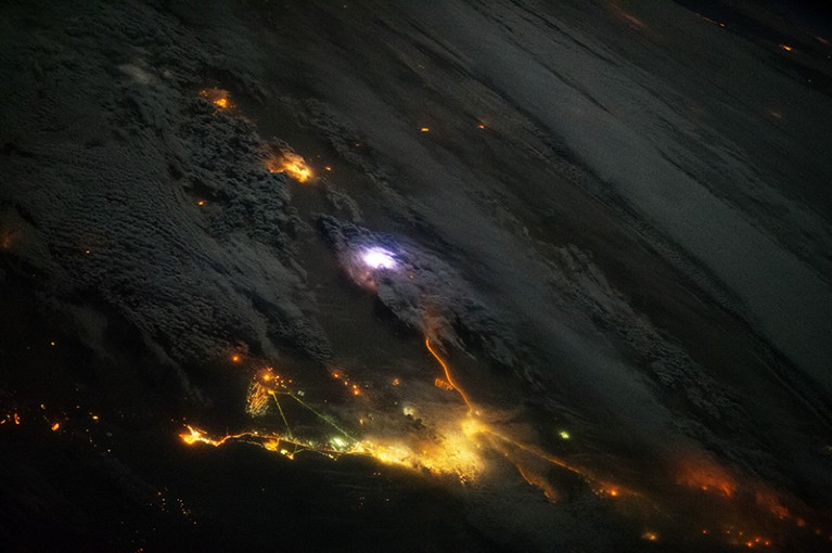 View from the International Space Station showing lightning amidst the yellow city lights of Kuwait and Saudi Arabia