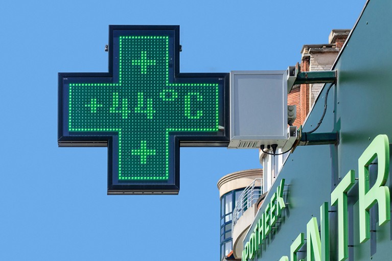 Thermometer in green pharmacy screen sign displays extremely hot temperature of 44 degrees Celsius during heatwav