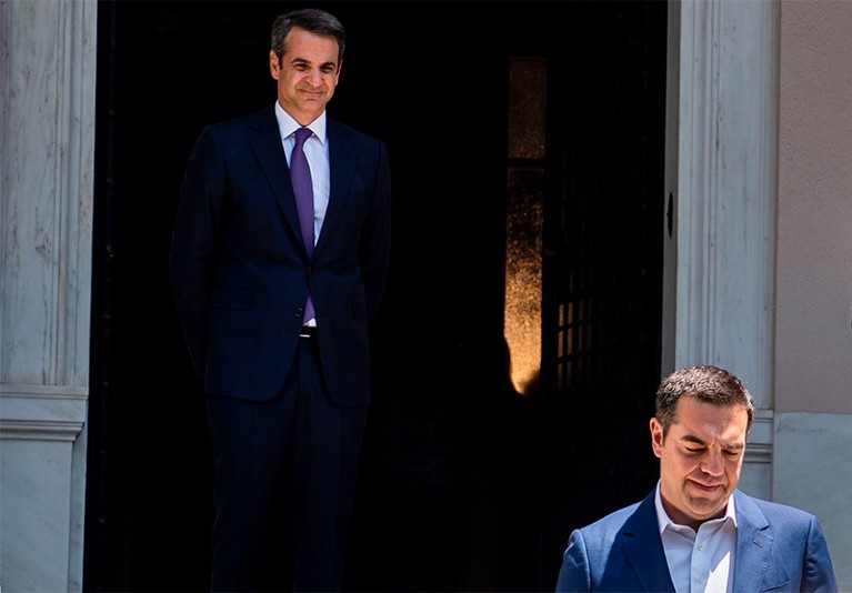 Greece's new Prime Minister Kyriakos Mitsotakis watches his predecessor Alexis Tsipras leave the Maximos Mansion