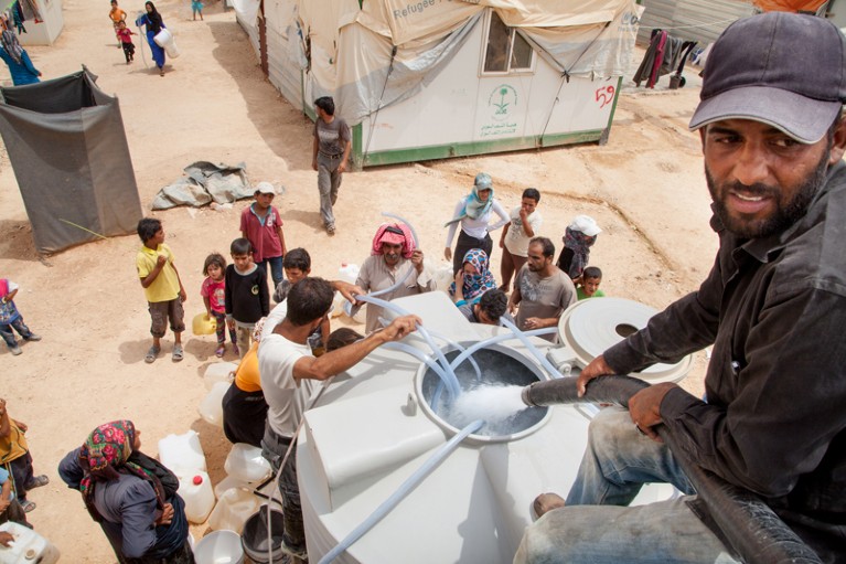 Water is distributed to refugees at the Zaatari Refugee camp near the Syrian border in Jordan
