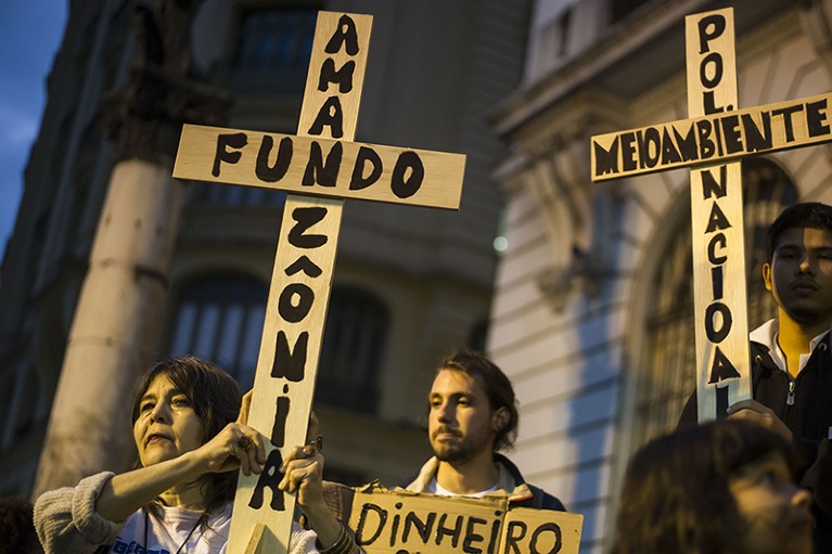 Brazilian protesters hold up crosses with legends against the environmental crisis in the Amazon on August 23rd 2019.