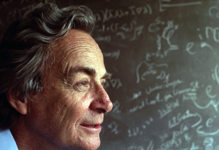 Richard Feynman stands in front of a blackboard strewn with notation in his lab in Los Angeles, in 1983