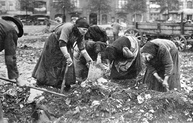 Poor German women sift through garbage looking for food in post war Germany, 1918